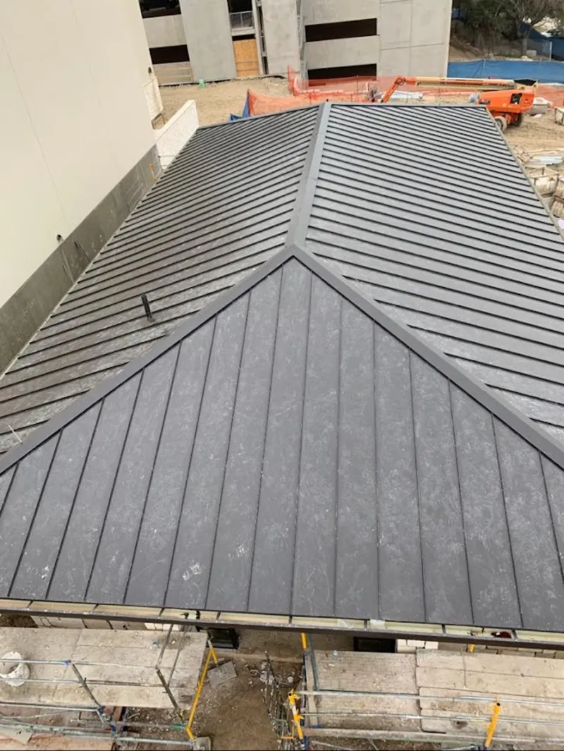 Commercial metal roof construction with crane equipment in Choctaw