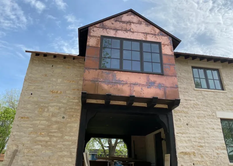 Copper metal panel facade on a stone building for Skylight Installation in Choctaw